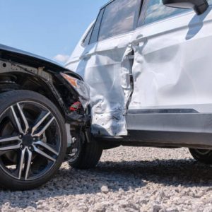 Damaged in heavy car accident vehicles after collision on city street crash site. Road safety and insurance concept.